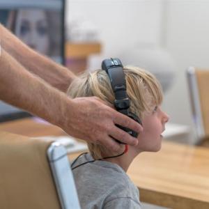 Hörakustiker macht Hörtest bei einem Kind.